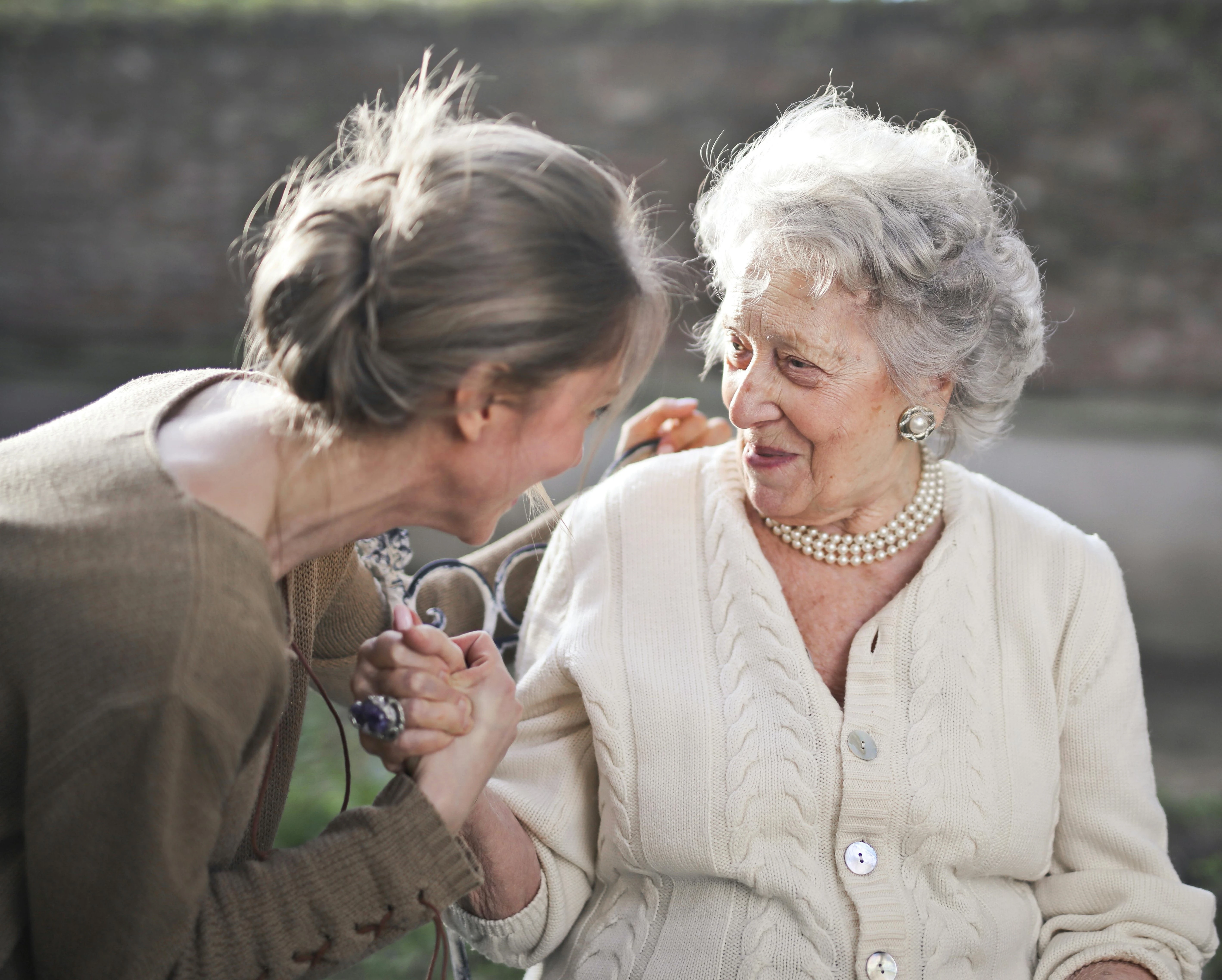 Eine jüngere und ältere Dame lächeln sich gegenseitig an
